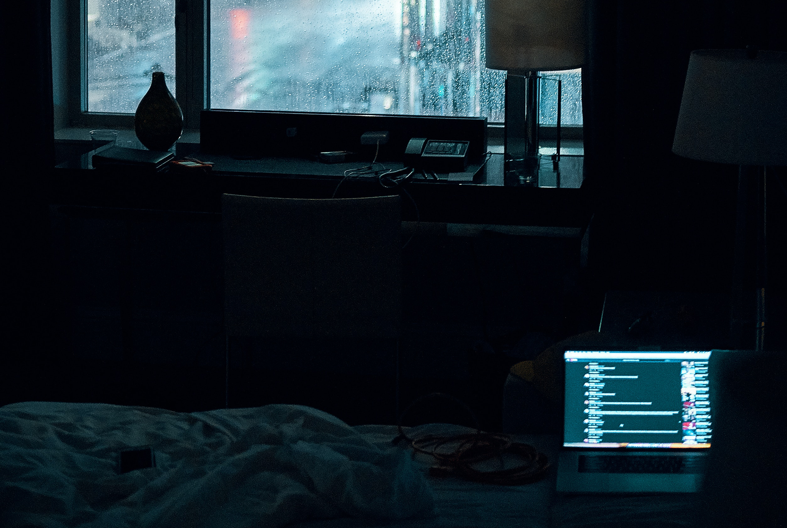 Image of a laptop on a bed in the dark